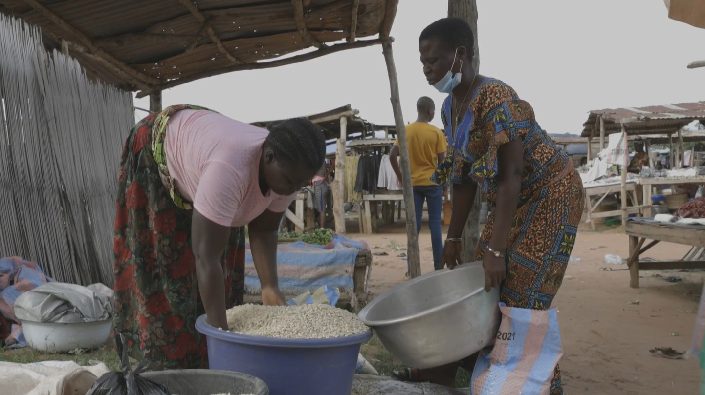 Adjelé Noumekpo purchases goods from a vendor in Djokoto, Togo