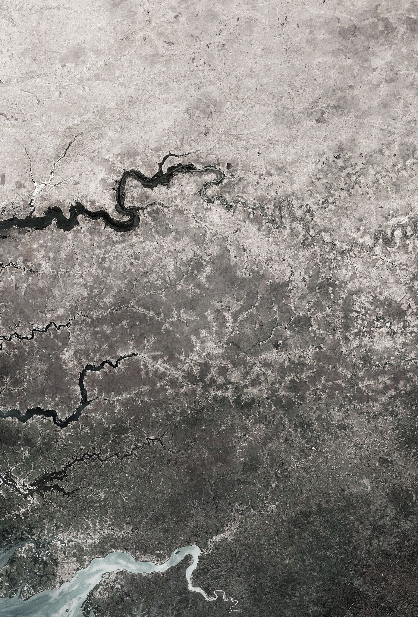 Captured by satellite imagery, this image shows the edge of the dry desert in west Africa contrasted with vegetated land. Signs of land degradation can be seen around villages and to a lesser extent along roads and rivers showing bare soil and degraded vegetation. The image shows parts of three African countries: Senegal, The Gambia and Guinea-Bissau. Credit: European Space Agency
