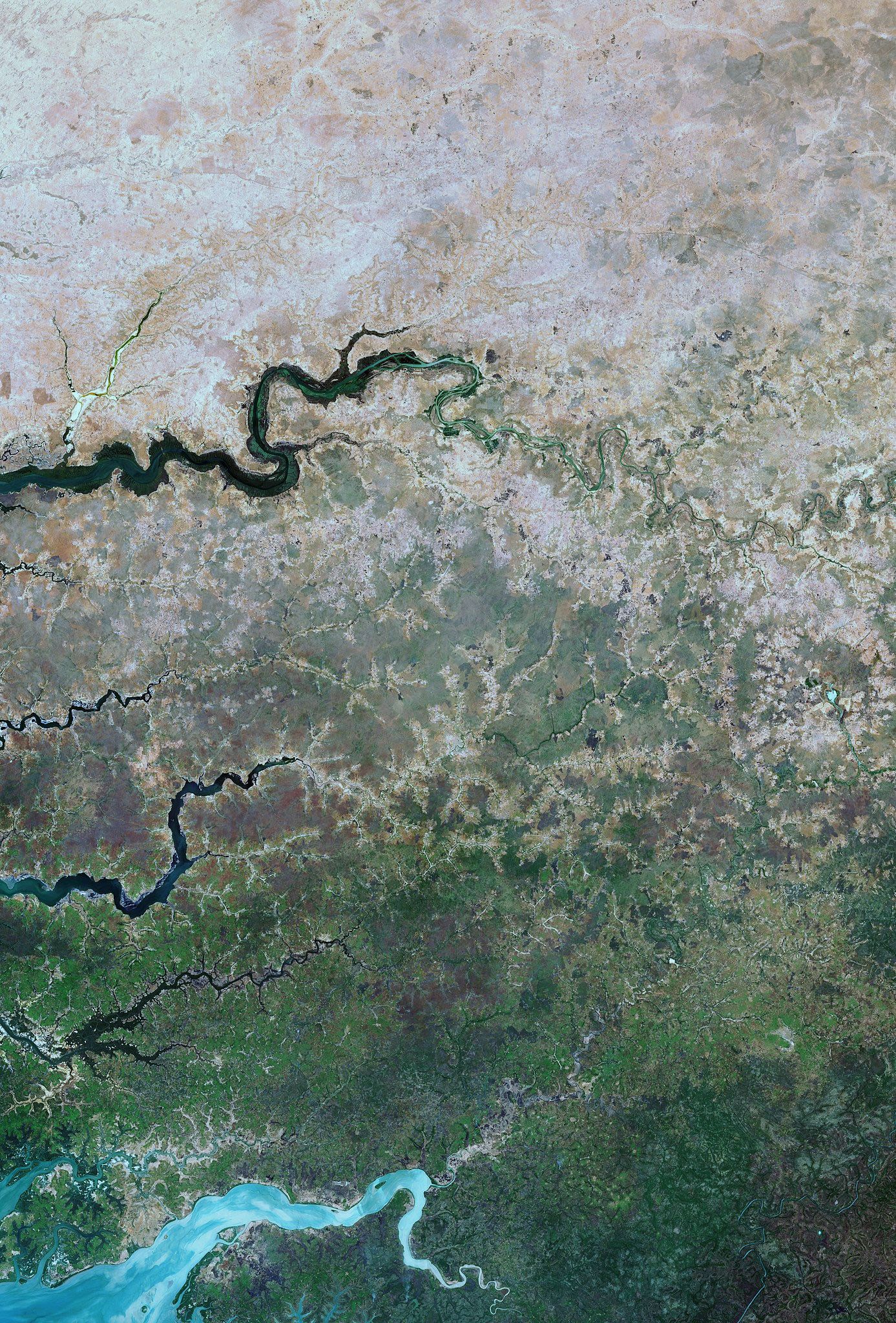 Captured by satellite imagery, this image shows the edge of the dry desert in west Africa contrasted with vegetated land. Signs of land degradation can be seen around villages and to a lesser extent along roads and rivers showing bare soil and degraded vegetation. The image shows parts of three African countries: Senegal, The Gambia and Guinea-Bissau. Credit: European Space Agency