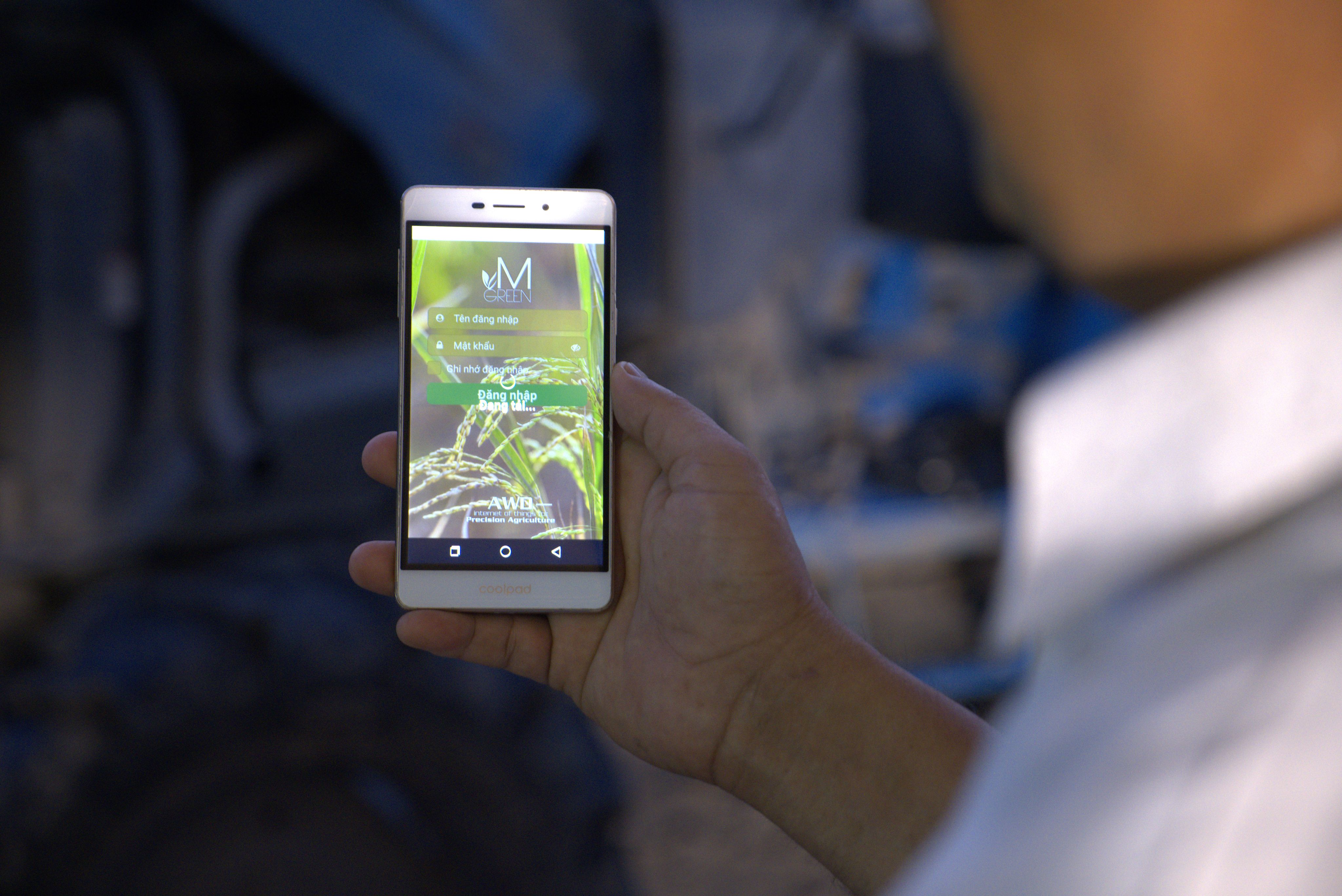 A Vietnamese farmer displays his mobile technology for monitoring and adjusting irrigation levels