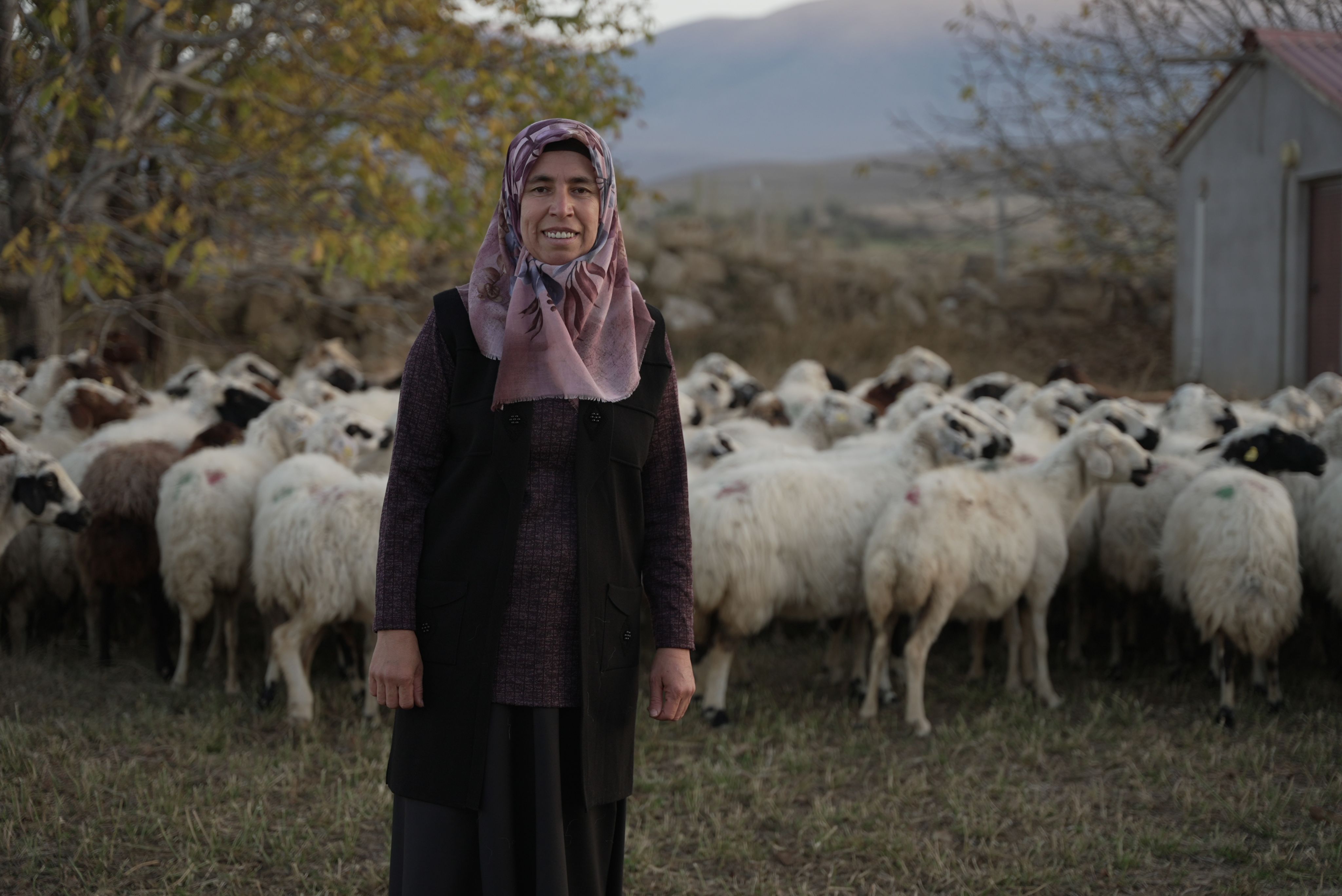 Portrait photo of female farmer in Turkey in front of her sheeps