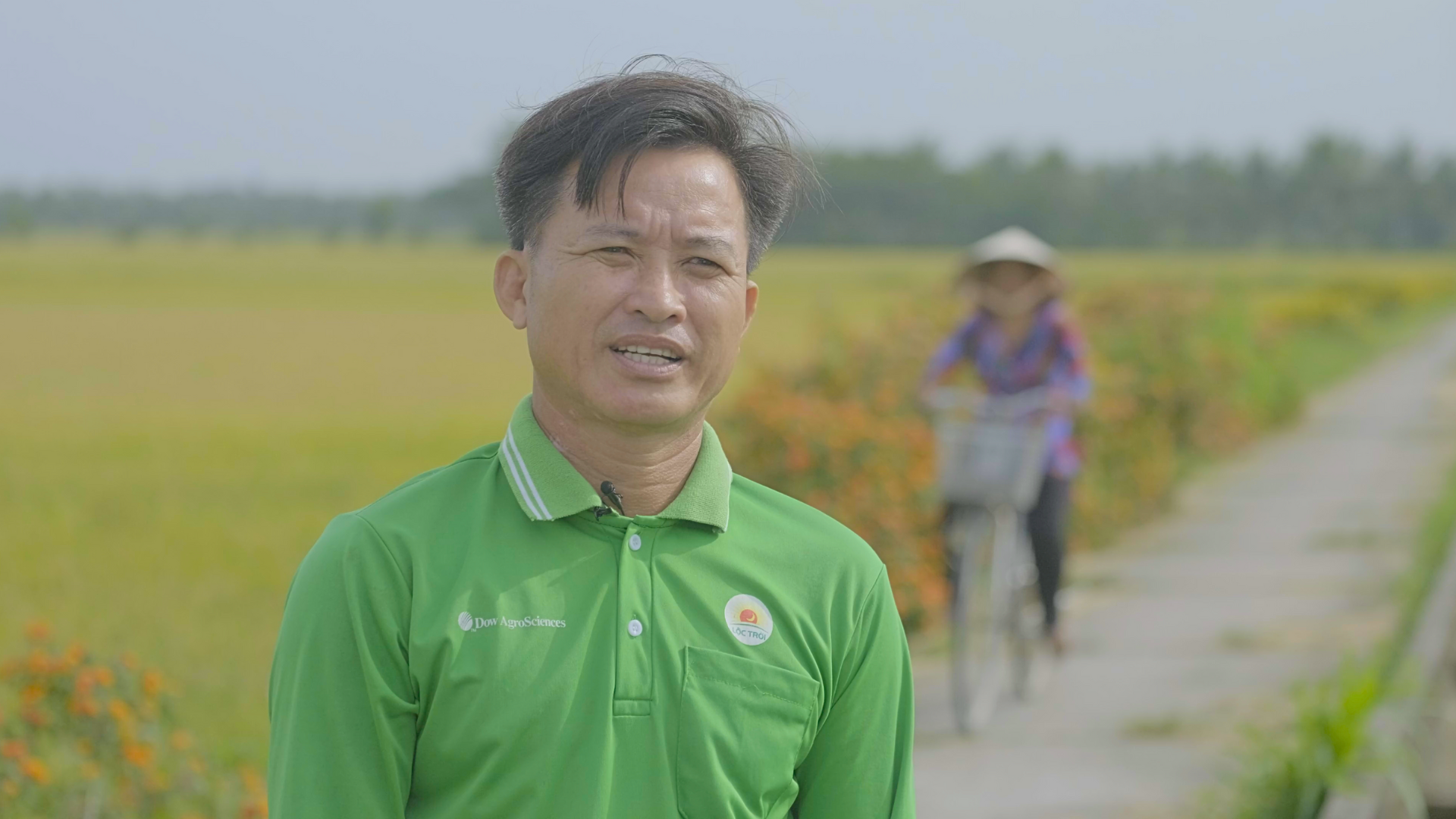 A closeup image of a male vietnamese rice farmer in front of his field