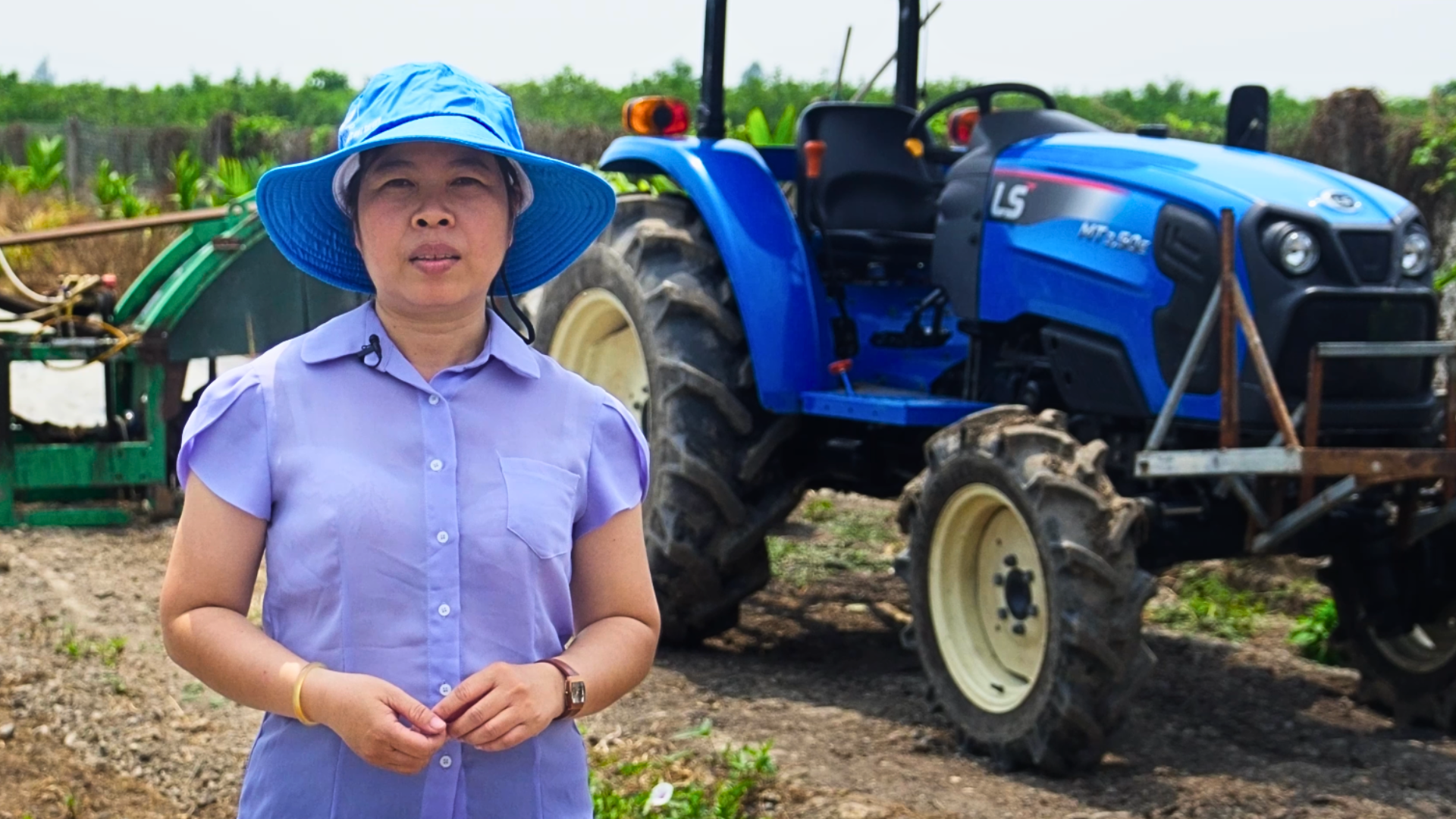 Photo of Vietnamese rice farmer in front of equipment